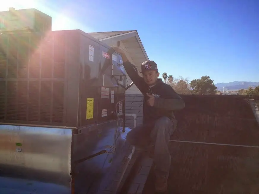 HVAC technician performing Air Duct Repair on a rooftop unit in Delafield